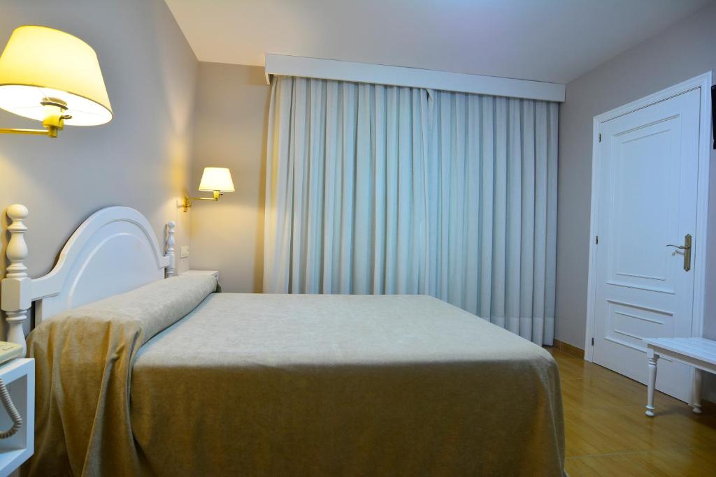 a hotel room with a bed and a window at Hotel Jucamar in Cangas de Morrazo