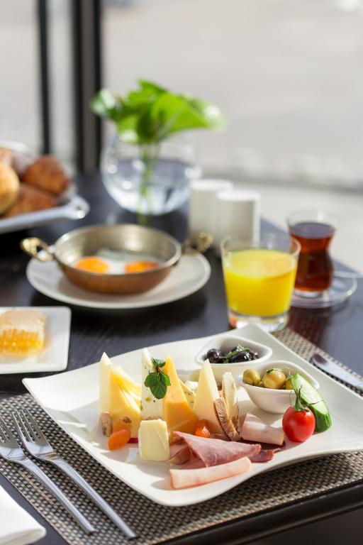 a table with a plate of food on a table at The Grand Tarabya Managed by Accor in Istanbul