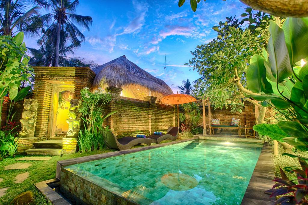 a swimming pool in a yard with a house at Imagine Bali in Ubud