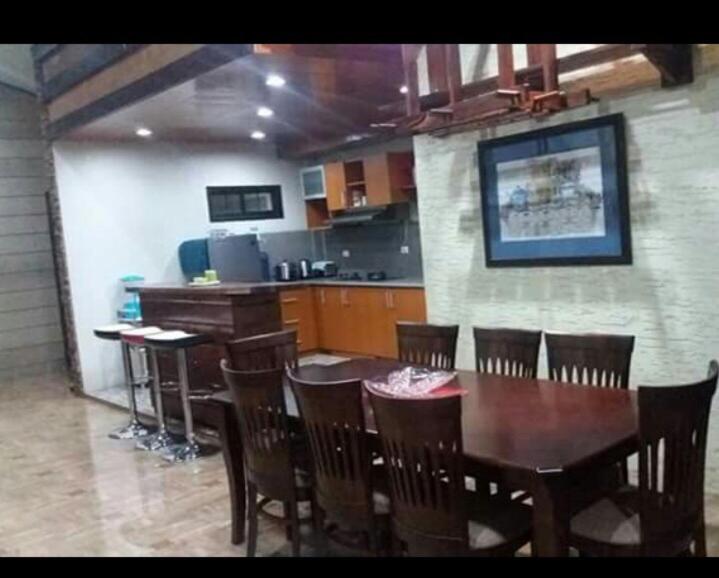 a dining room with a wooden table and chairs at Affordable Baguio APT in Baguio