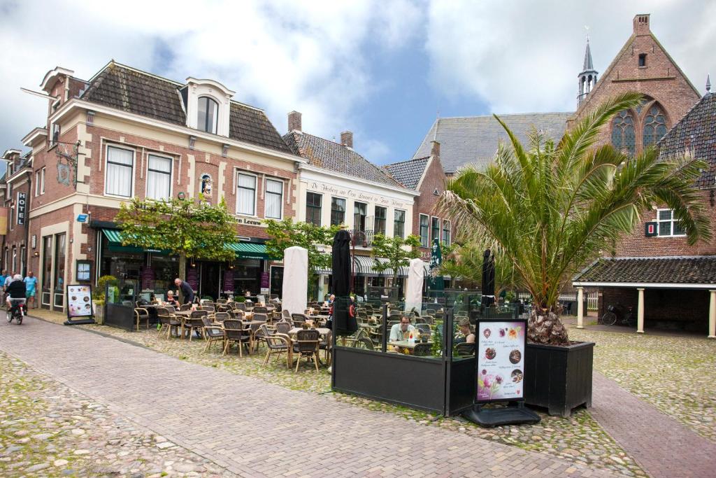 una calle con mesas y sillas frente a un edificio en Hotel de Gulden Leeuw, en Workum