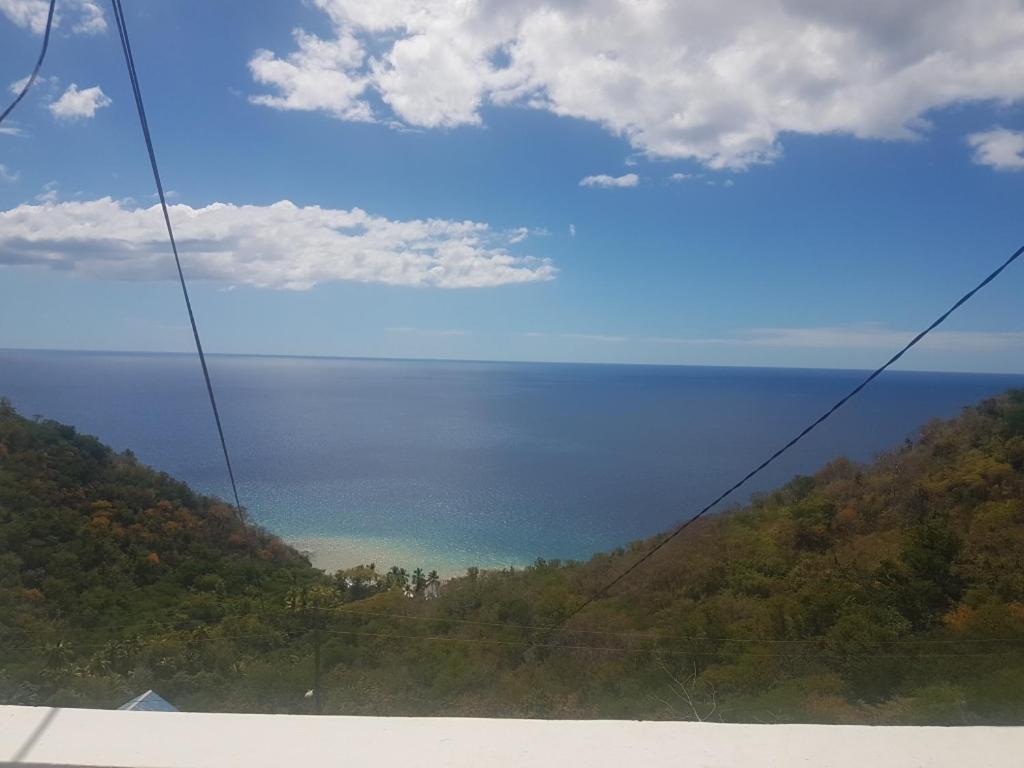 una ventana de autobús con vistas al océano en Evie Cottage, en Bioche