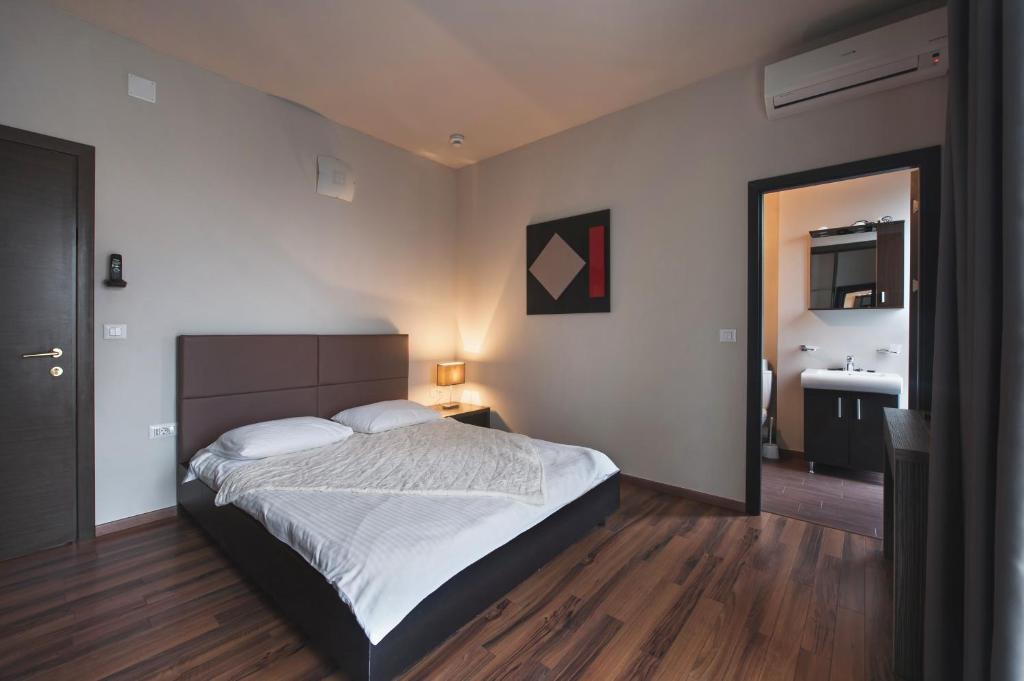 um quarto com uma cama grande e uma casa de banho em Hotel Hemingway Residence em Bucareste