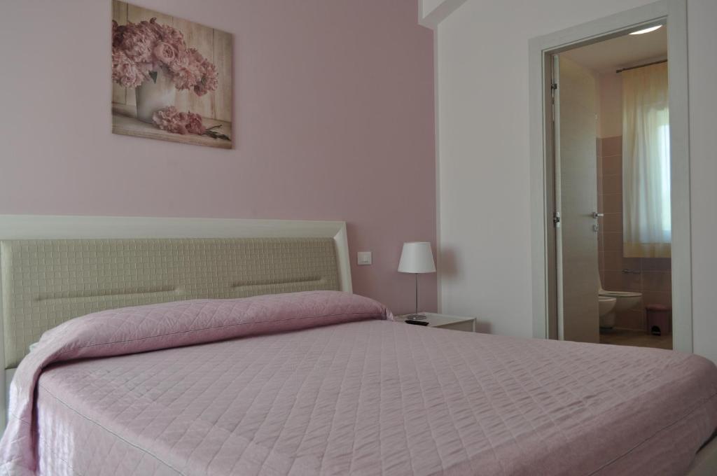 ヌマーナにあるVerde Giadaのベッドルーム1室(ピンクの毛布付きの大型ベッド1台付)