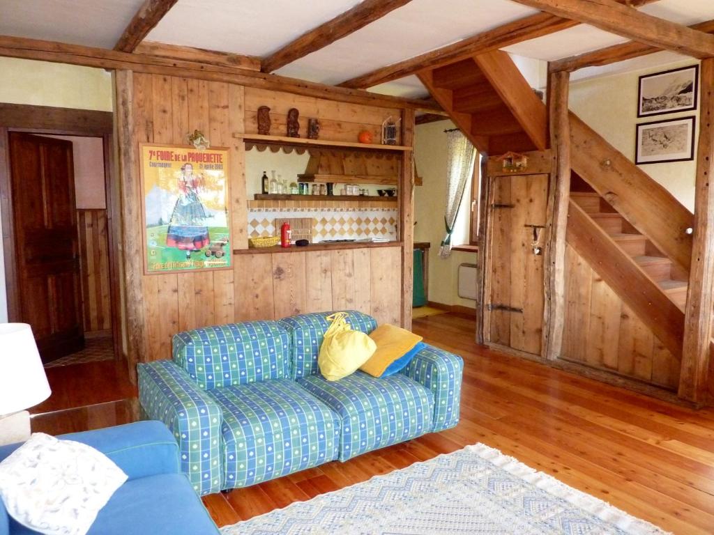 salon z niebieską kanapą i drewnianymi ścianami w obiekcie Maison Angèle w mieście Saint-Nicolas