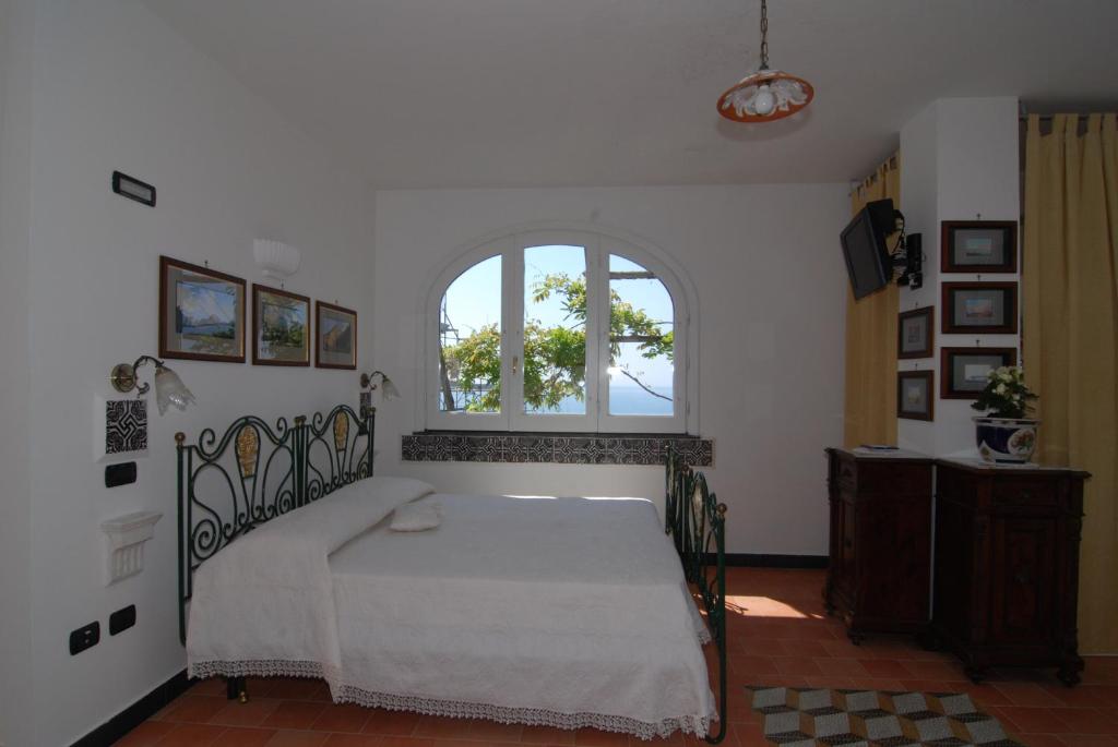 a bedroom with a bed and a window at Bella Baia Relais in Maiori