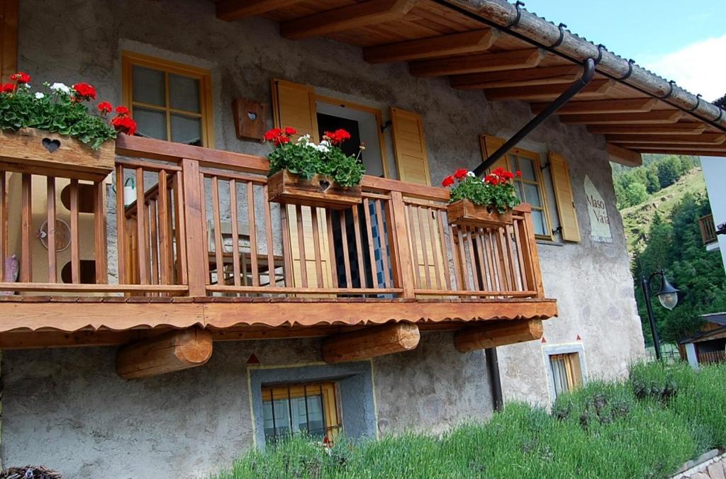 a building with a balcony with flowers on it at Maso Vaia in Cavalese