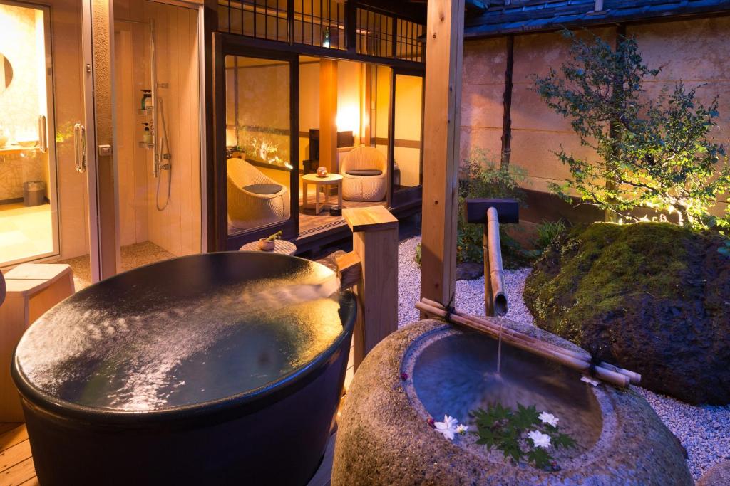 a bathroom with a bath tub and a sink at Nazuna Kyoto Nijo-jo in Kyoto