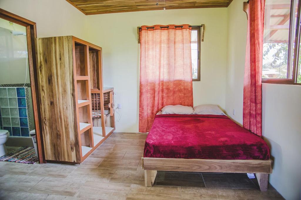 a bedroom with a bed and a bathroom with a shower at Suites Chile Verde in Manzanillo