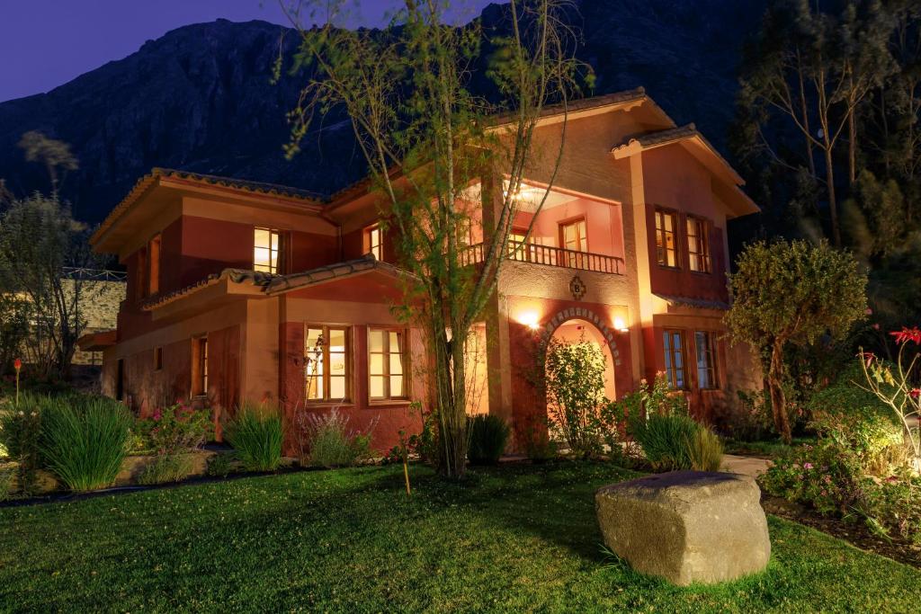 a large house with lights on in the yard at Hotel Pakaritampu in Ollantaytambo