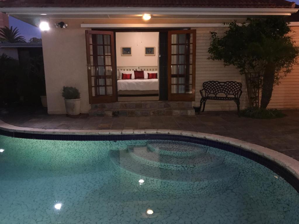 伊麗莎白港的住宿－薩特普拉斯賓館，夜间在房子前面的游泳池