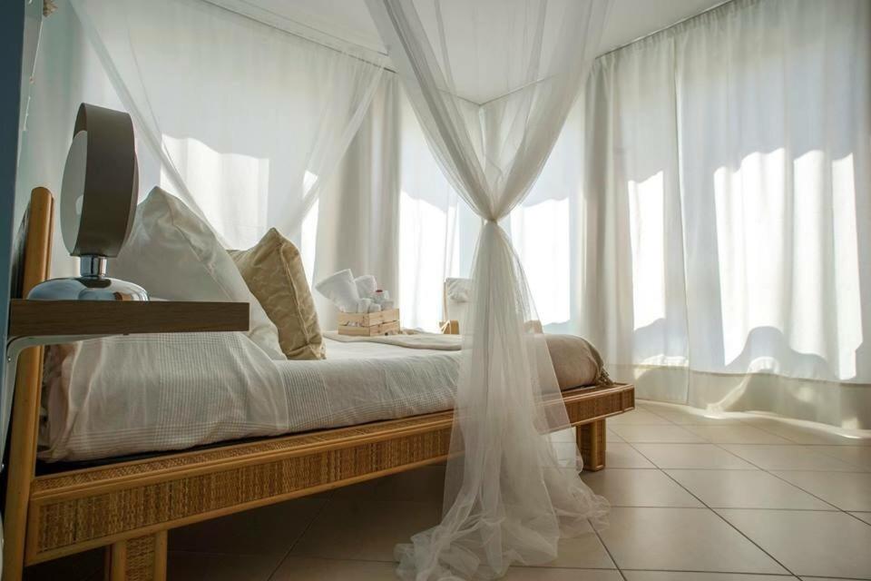 サン・レオーネにあるL'Approdoのベッドルーム1室(白いカーテンと窓付)
