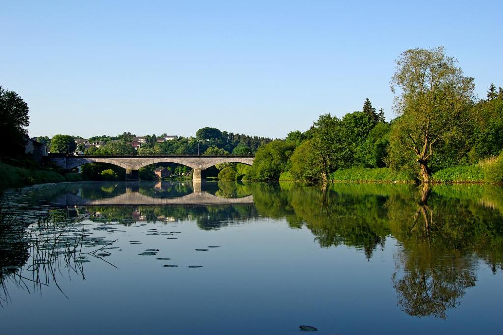 a bridge over a river with its reflection in the water at Ferienwohnung Unica im Lahntal in Villmar