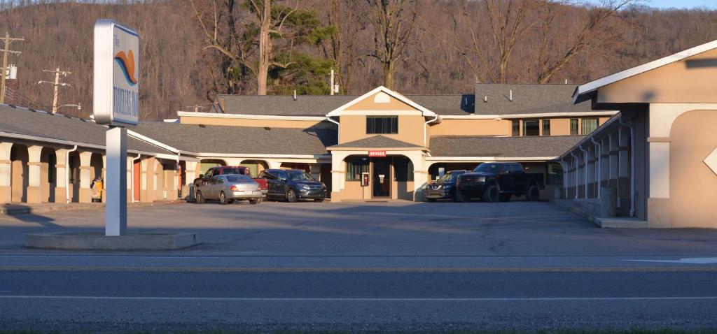 una fila de edificios con coches estacionados en un estacionamiento en Travelers Inn, en New Martinsville
