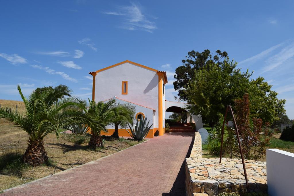 Una pequeña casa blanca con un camino que conduce a ella. en Quinta da Aurora, en Évora