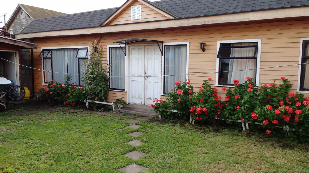 a house with red flowers in front of it at Cabaña Don Claudio in Osorno