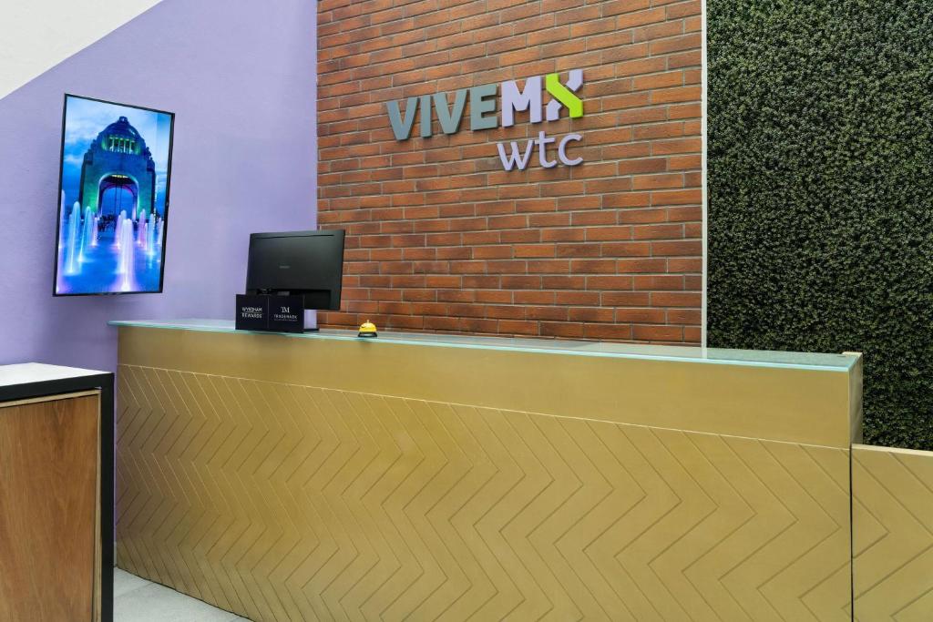 A reception desk backed by a brick VIVE MX WTC feature wall.