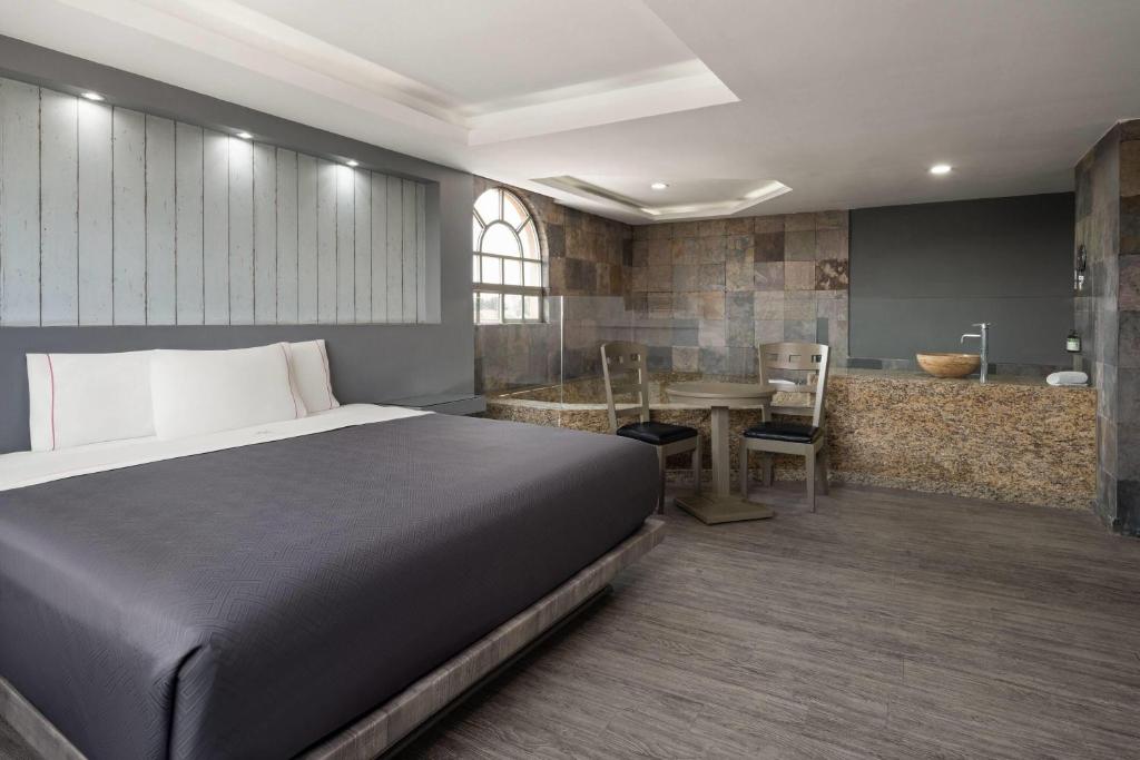 A bedroom opens onto a stone-finished bathroom with a small two-person dining area.