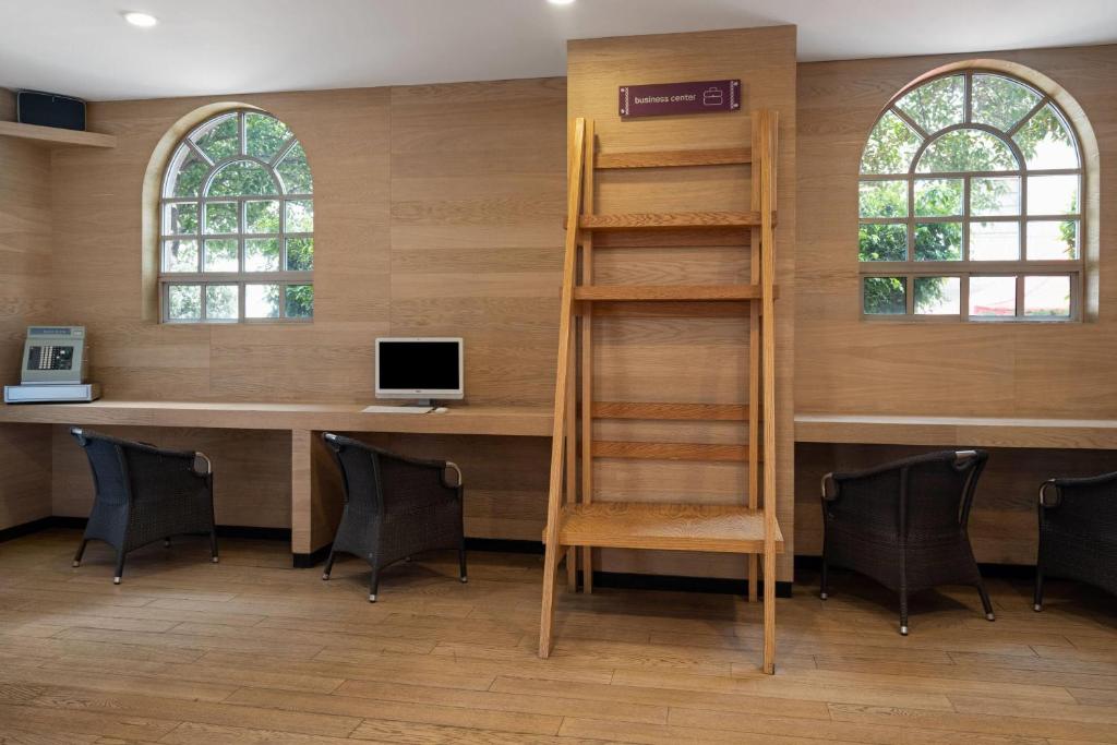A shared work counter with computers, chairs, arched windows, and a central shelving unit.