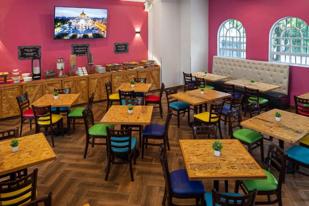 A colorful dining room with buffet counters, wooden tables, and mixed chairs.