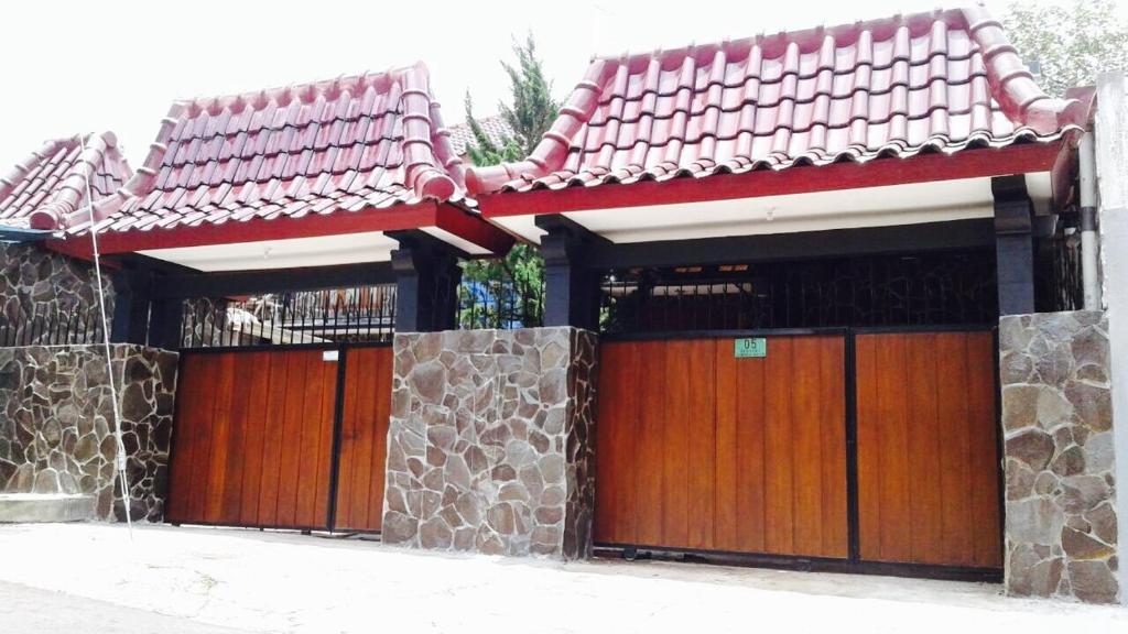 dom z dwoma garażami z drewnianymi drzwiami w obiekcie Villa Cabean Salatiga w mieście Salatiga