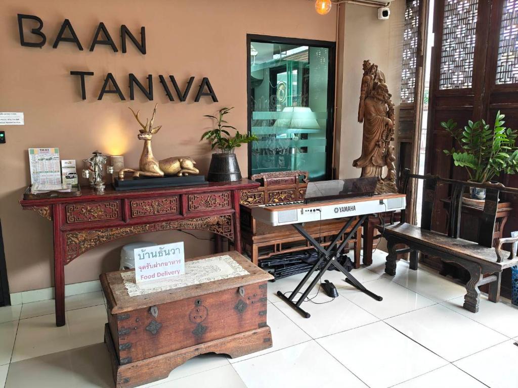 A decorative lobby corner with a Yamaha keyboard, carved furniture, and hotel signage.