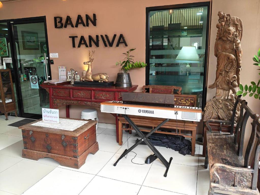 A tiled entrance display with a Yamaha keyboard, carved chairs, and traditional wooden furniture.