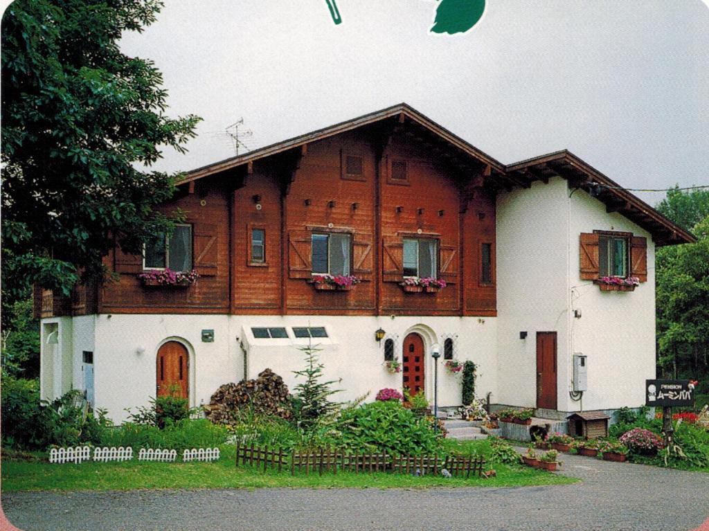 a large wooden house with at Pension Moomin Papa in Myoko