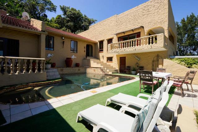 a house with a swimming pool and some chairs at Villa Valencia in Pinetown