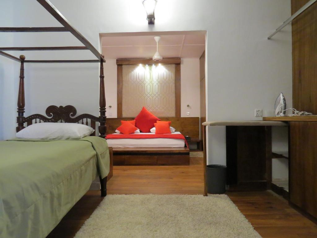 a bedroom with two beds with orange pillows at Dees Homestay Colombo in Colombo