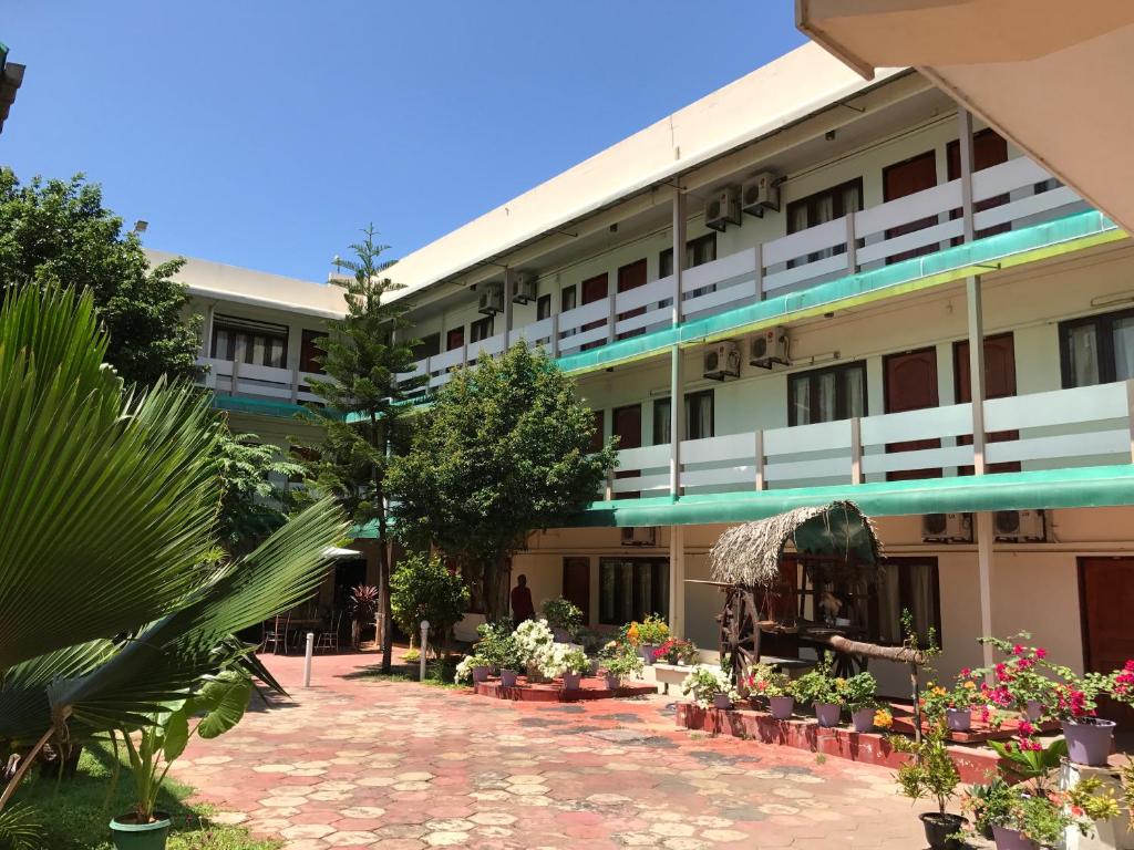 a large building with plants in front of it at Gnaanams Hotel and Restaurant in Jaffna