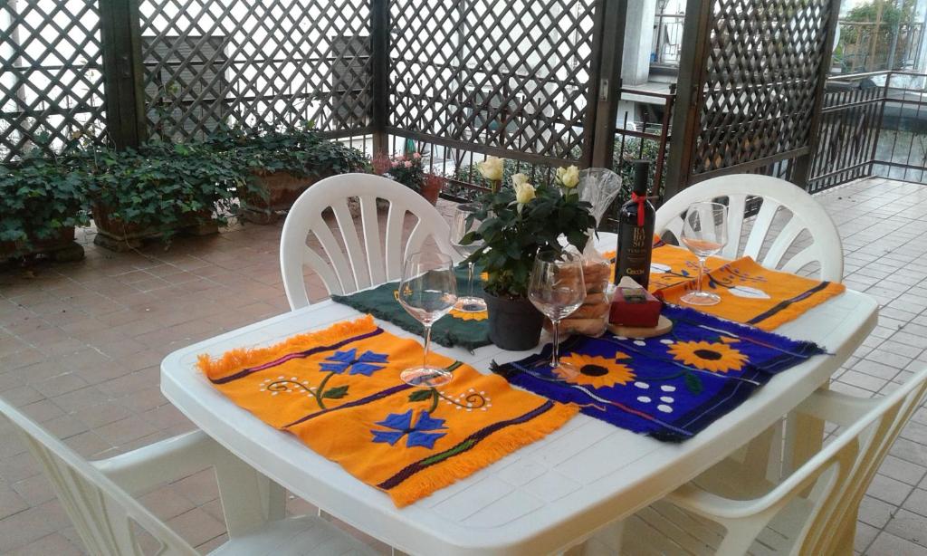 una mesa blanca con sillas y copas de vino. en Il Sole, en Padua