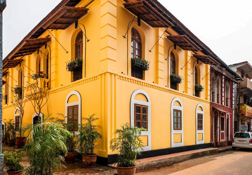 a yellow building with plants in front of it at Mateus Boutique Hotel in Panaji