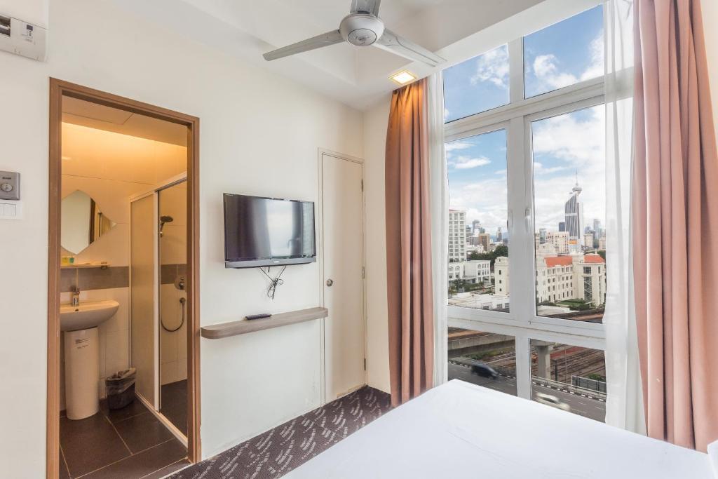 ein Zimmer mit einem großen Fenster mit Blick auf die Stadt in der Unterkunft Scott Hotel KL Sentral in Kuala Lumpur