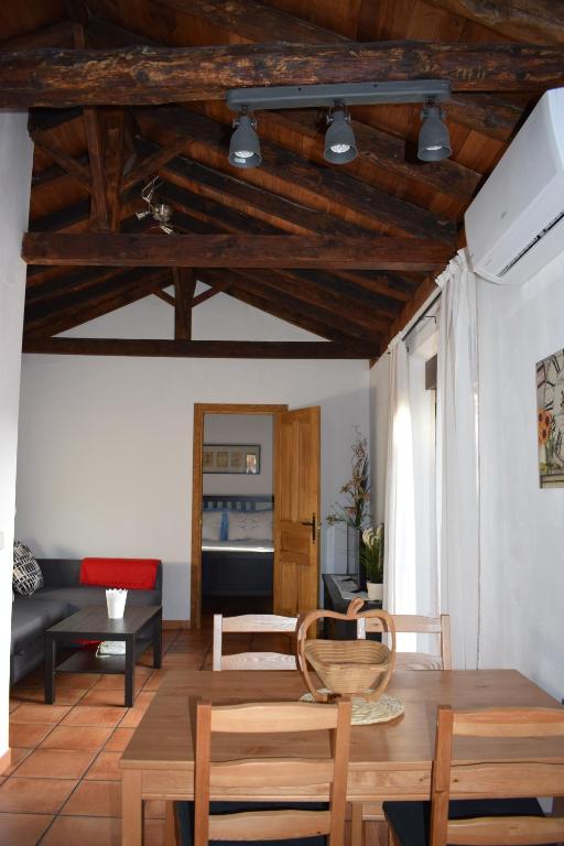 a living room with wooden ceilings and wooden chairs at Apartamento Mercedes in Cobisa