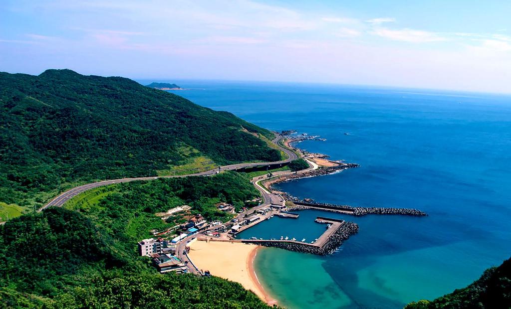 eine Luftansicht auf einen Strand und das Meer in der Unterkunft Blue Coast Spa Motel in Keelung