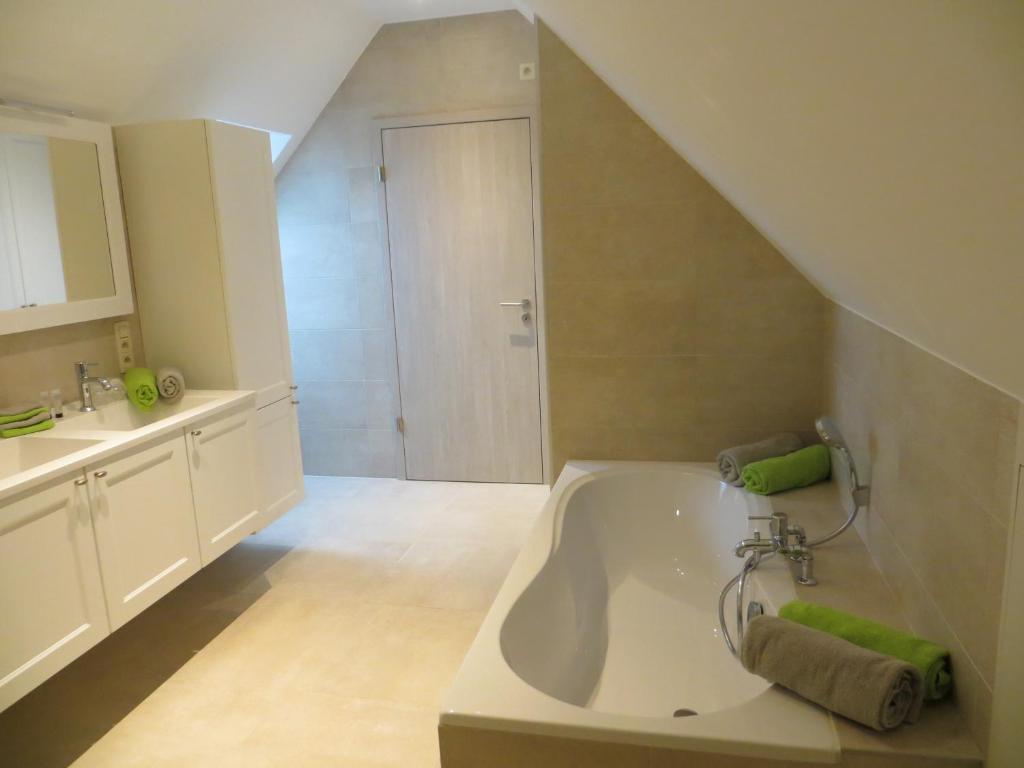 een badkamer met een bad en een wastafel bij B&B 't Hannonshof in Nieuwpoort