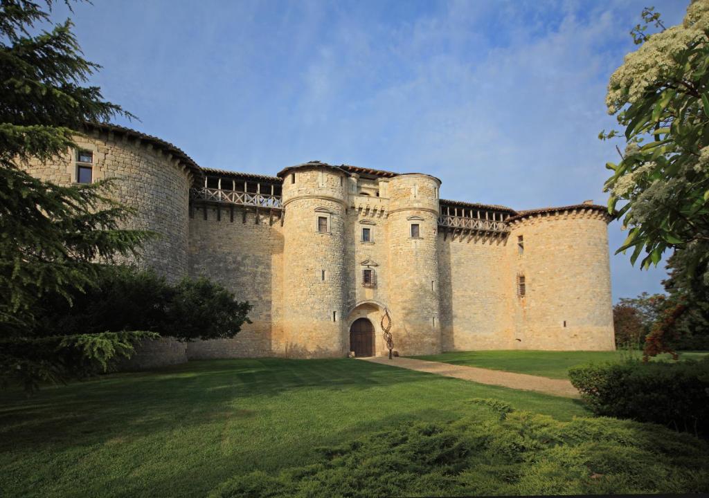 a large castle with a grass field in front of it at château de Mauriac in Senouillac