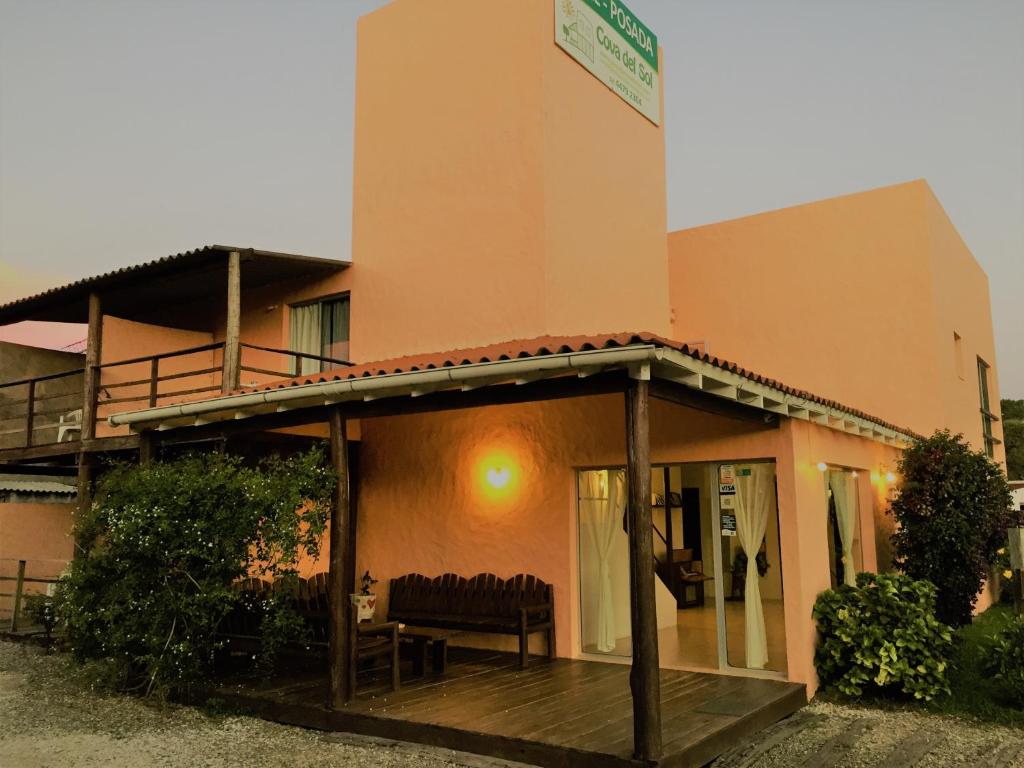 un edificio con un porche con un banco. en Posada Cova Del Sol, en La Pedrera