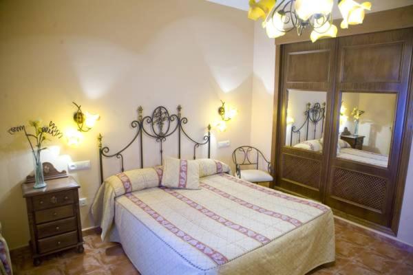 a bedroom with a large bed and a mirror at Hostal Restaurante Dulcinea de El Toboso in El Toboso