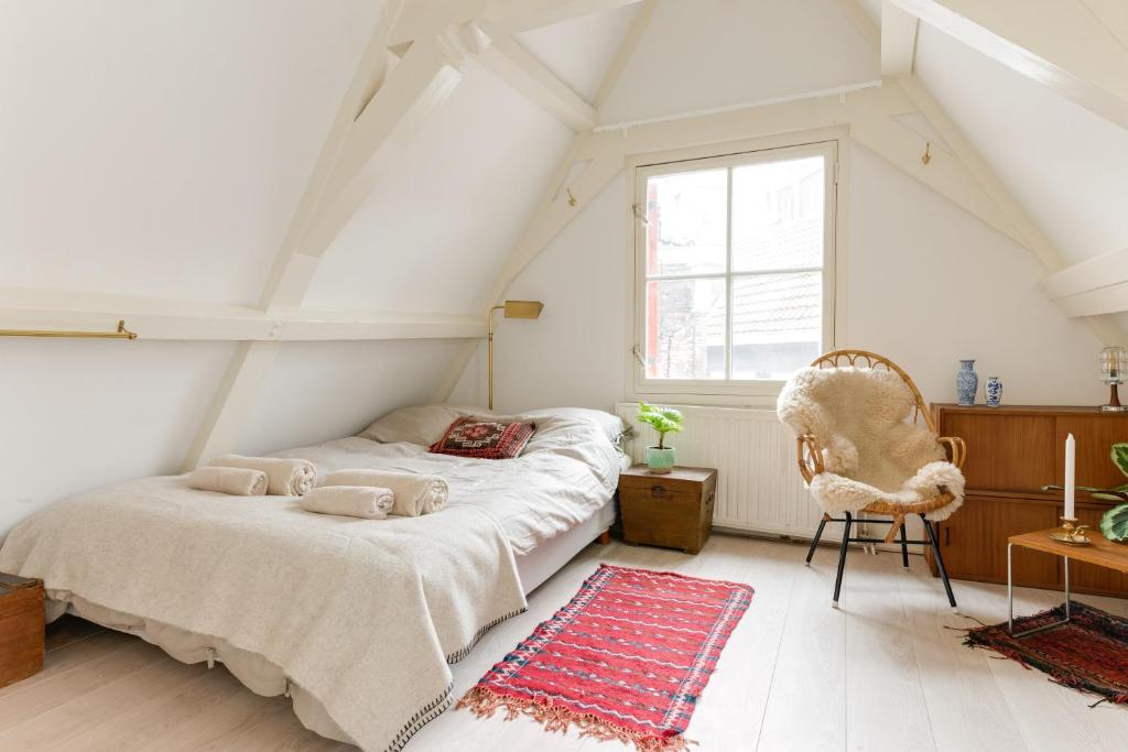 a bedroom with a bed and a chair and a window at Rembrandt Studio's in Amsterdam