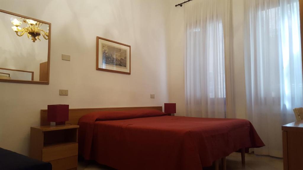a bedroom with a red bed and a window at rialto1082 in Venice