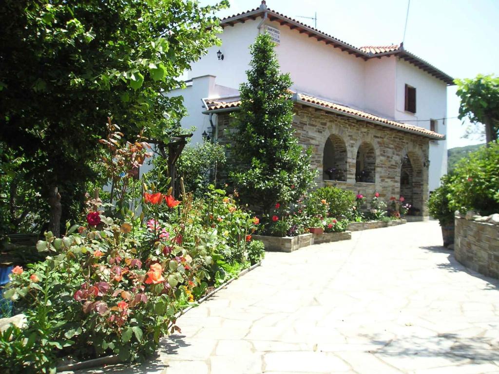 a garden in front of a house with flowers at Felitsia Apartments & Studios in Agios Ioannis Pelio