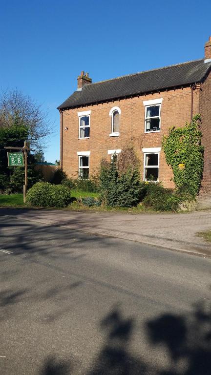 una calle vacía frente a un edificio de ladrillo en Victoria Farm, en Lutterworth