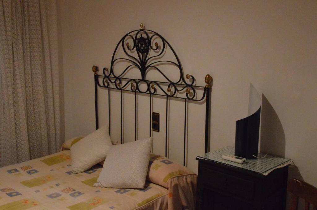 a bedroom with a bed and a computer on a desk at Casa vitorianet in Alcampel