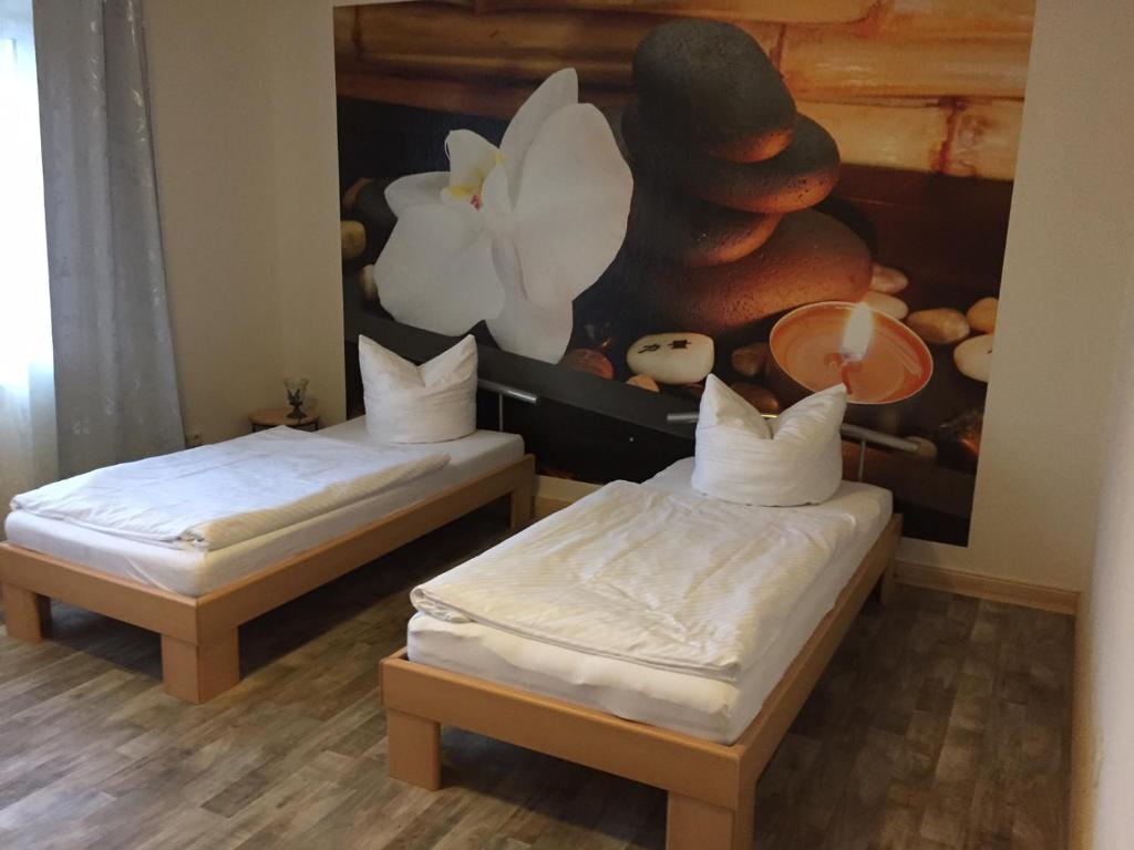 2 Betten in einem Zimmer mit Wandgemälde in der Unterkunft Pension No. 12 in Ketzin