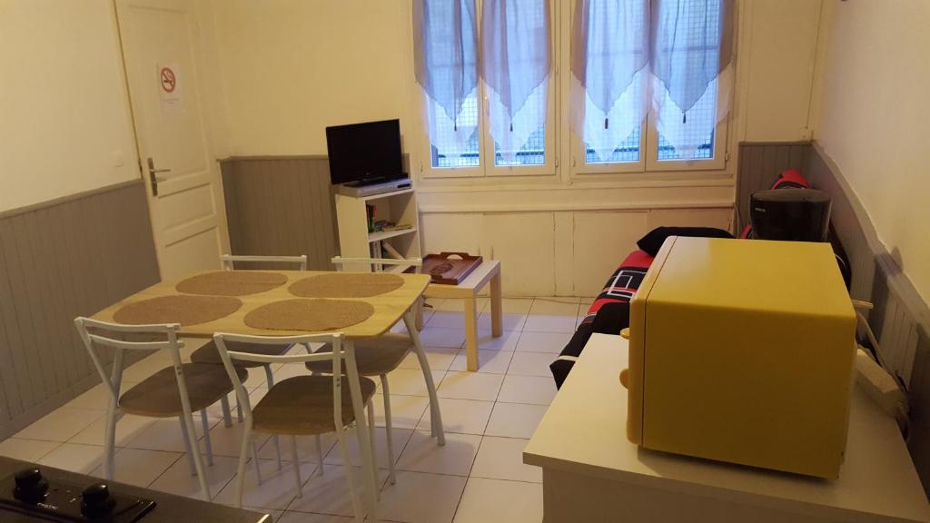 アグドにあるLes Lavandesのテーブル、椅子、テレビが備わる小さな客室です。