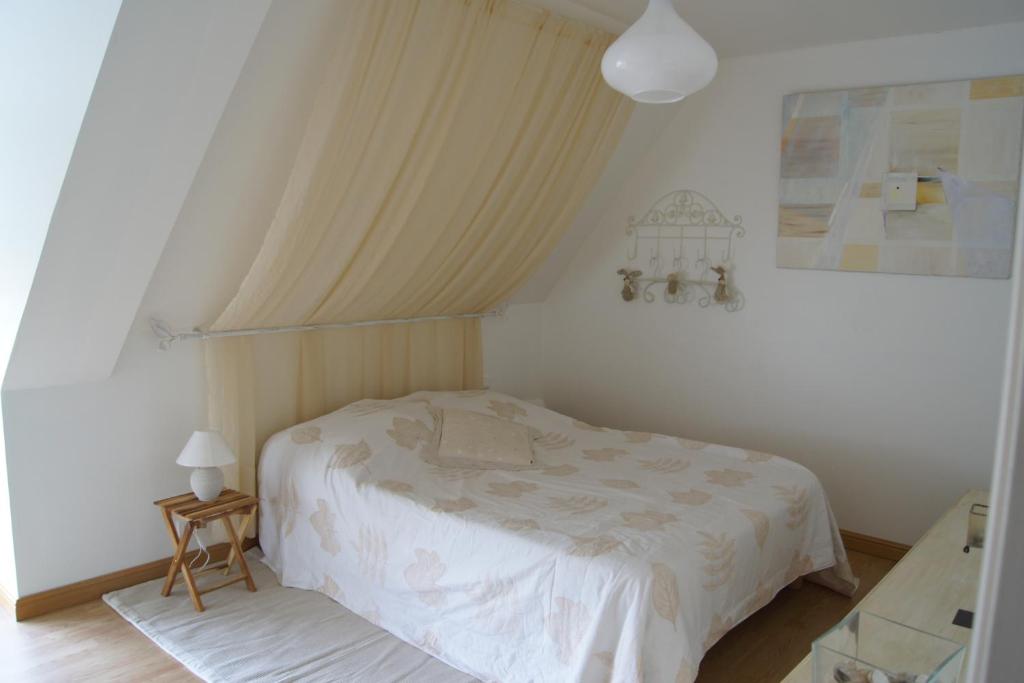 a bedroom with a white bed in a room at Gîtes du Vieux Presbytère in Baguer-Pican