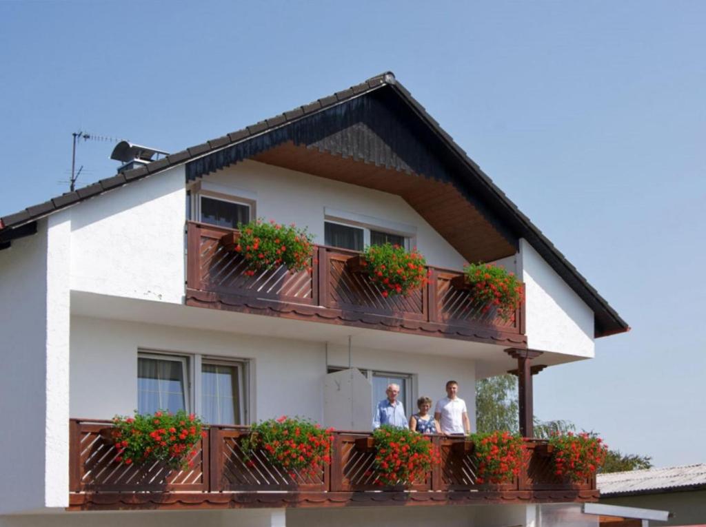 a family standing on a balcony of a house at Gästehaus Brunner in Egglfing
