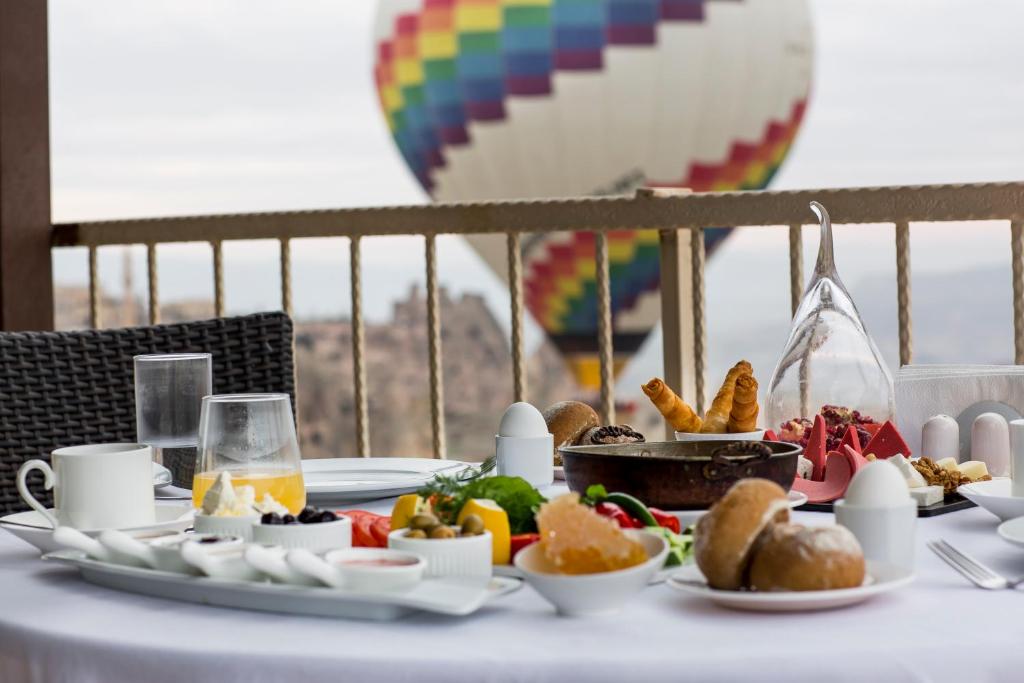 a table with a breakfast of food and a hot air balloon at Uchisar Kaya Otel in Uçhisar